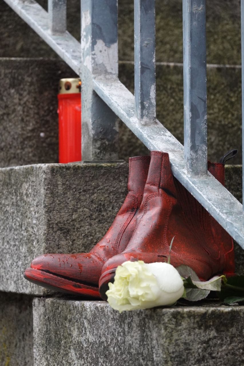 Rotes Schuhpaar mit weißer Rose